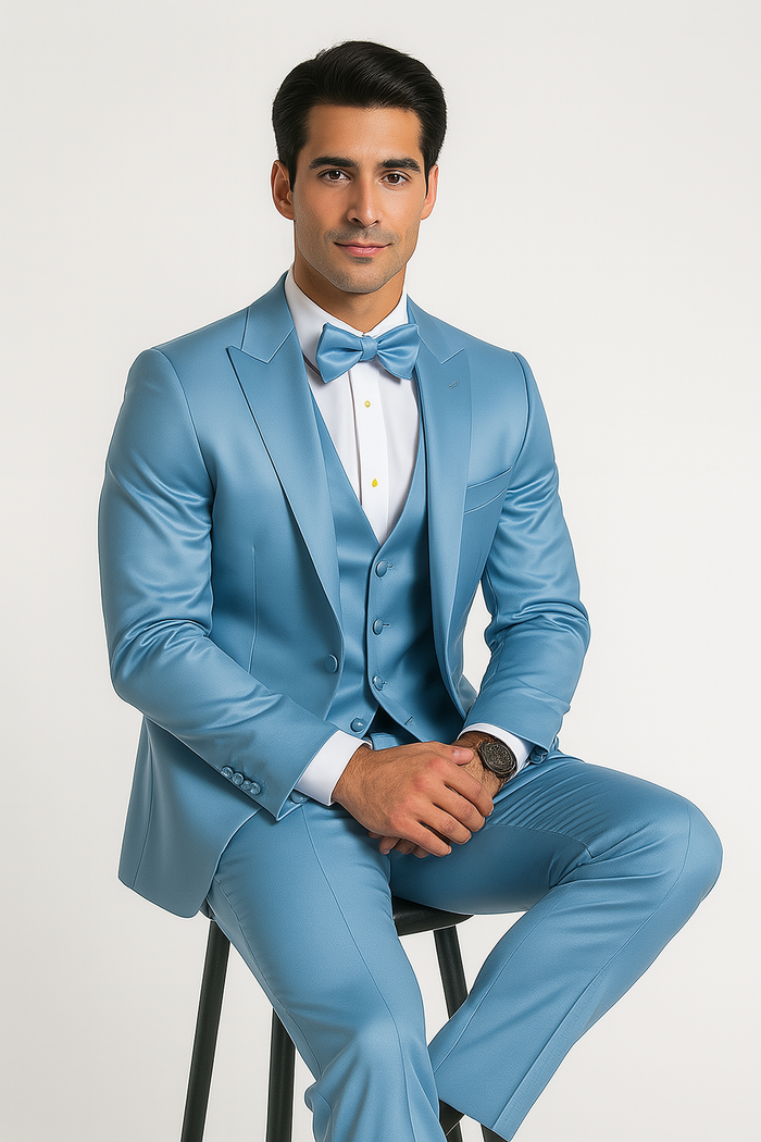 Light blue tuxedo set: fitted blazer with satin finish, matching vest & pants, bow tie. Smooth, light blue fabric with sheen. Peaked blazer collar, buttoned vest, classic bow tie design.
