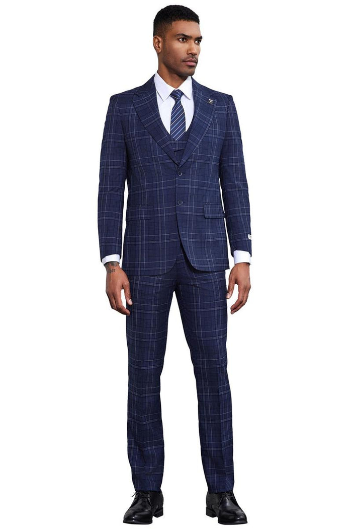 Navy Stacy Adams suit: two-button jacket with notch lapel, side pockets. Matching slim-fit trousers. Navy base with light windowpane plaid. Fitted, tailored look.
