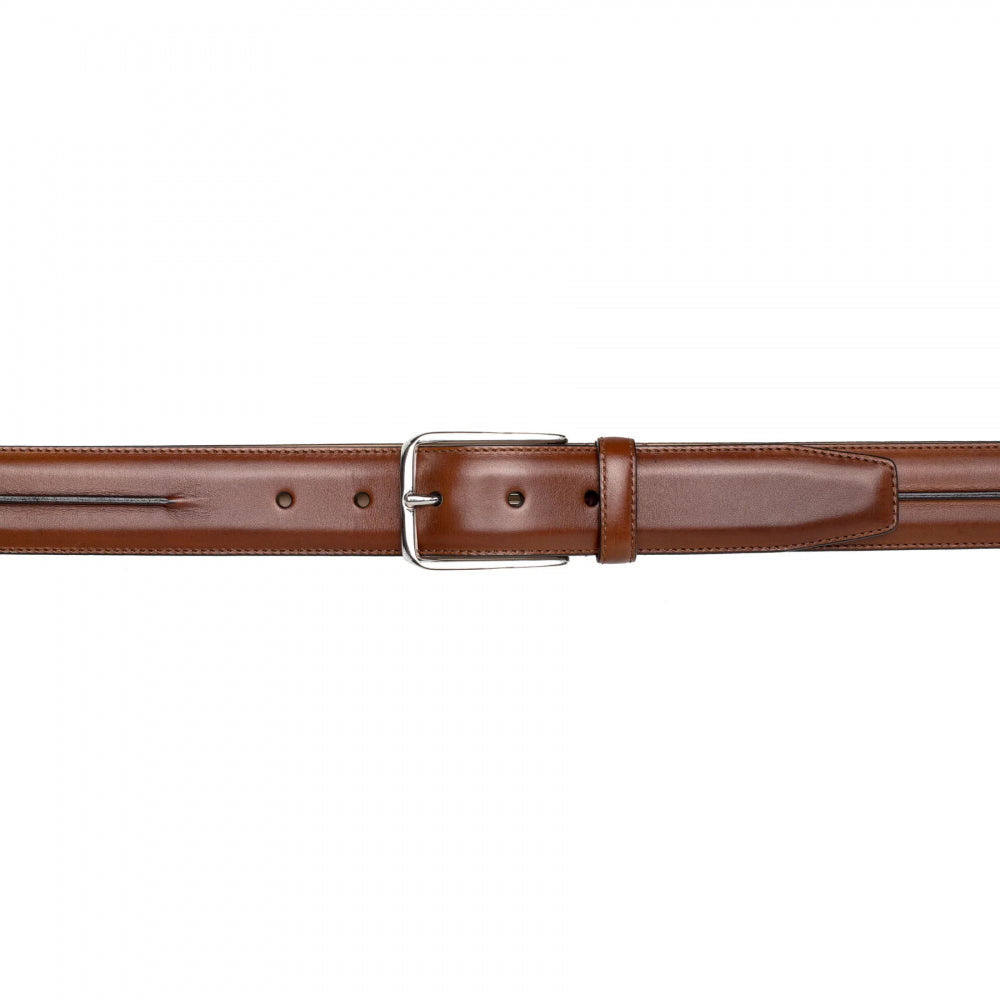 Mezlan Cognac calfskin belt with glossy finish. Features a silver-tone buckle, classic straight form, and subtle edge piping. Offers adjustable sizing.
