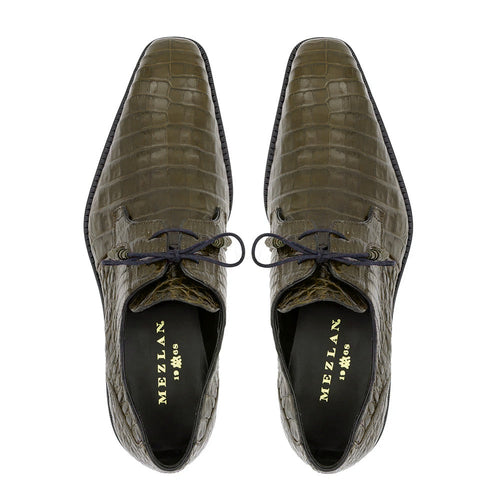 Olive green Mezlan Anderson derby shoes with crocodile skin texture. Pointed toe, laced design, and black sole. High-quality craftsmanship with a comfortable interior lining.
