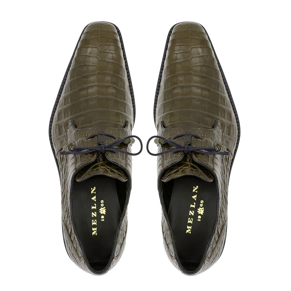 Olive green Mezlan Anderson derby shoes with crocodile skin texture. Pointed toe, laced design, and black sole. High-quality craftsmanship with a comfortable interior lining.
