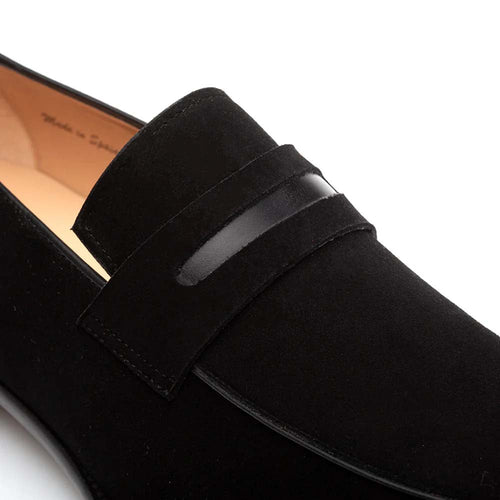Mezlan Galeno black suede penny loafer. Sleek silhouette with rounded toe. Soft black suede upper. Smooth leather band detail. Low heel, slightly raised back. Light interior lining contrasts the black.
