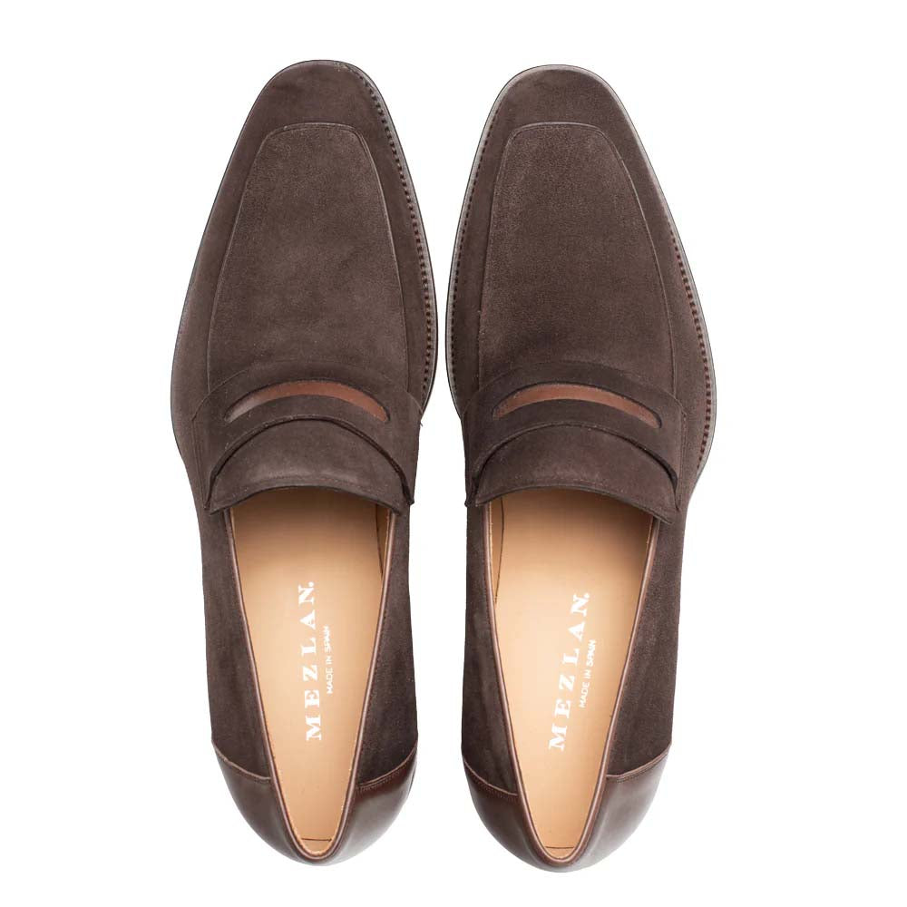 Mezlan Galeno penny loafer in dark brown suede. Classic slip-on design with squared toe and instep band. Leather lined, subtle stitching, and contrasting dark sole for a distinct look.
