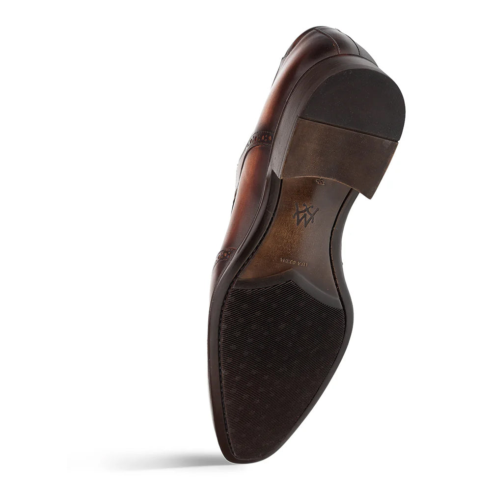 Mezlan Tasso wingtip derby in chestnut. Smooth brown leather upper with tonal variations. Composite sole with textured traction. Layered heel for elevation.
