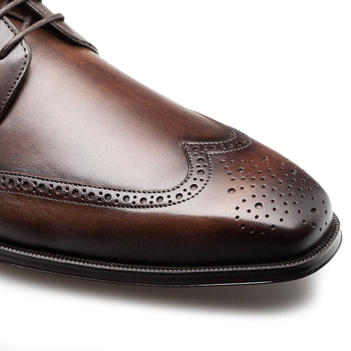 Mezlan Tasso wingtip derby in chestnut. Smooth leather upper, intricate wingtip design with perforations. Rounded toe, distinct lacing area, matching brown leather sole.
