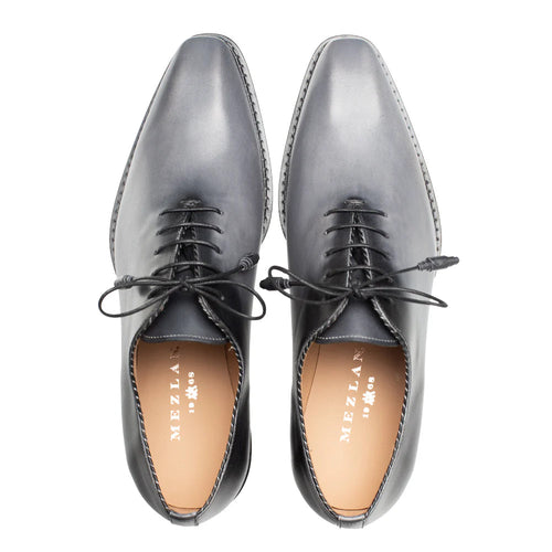 Mezlan Barbaro oxford: Two-tone grey/black gradient. Smooth leather upper with pointed toe and lace-up closure. Tan leather lining. Decorative stitched sole edge.
