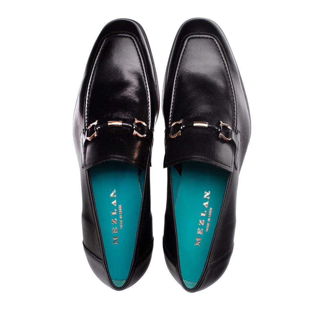Mezlan Rios Flex Loafer in black: slip-on, pointed toe, smooth leather. Metallic chain ornament. Turquoise insole. Flexible, durable sole.
