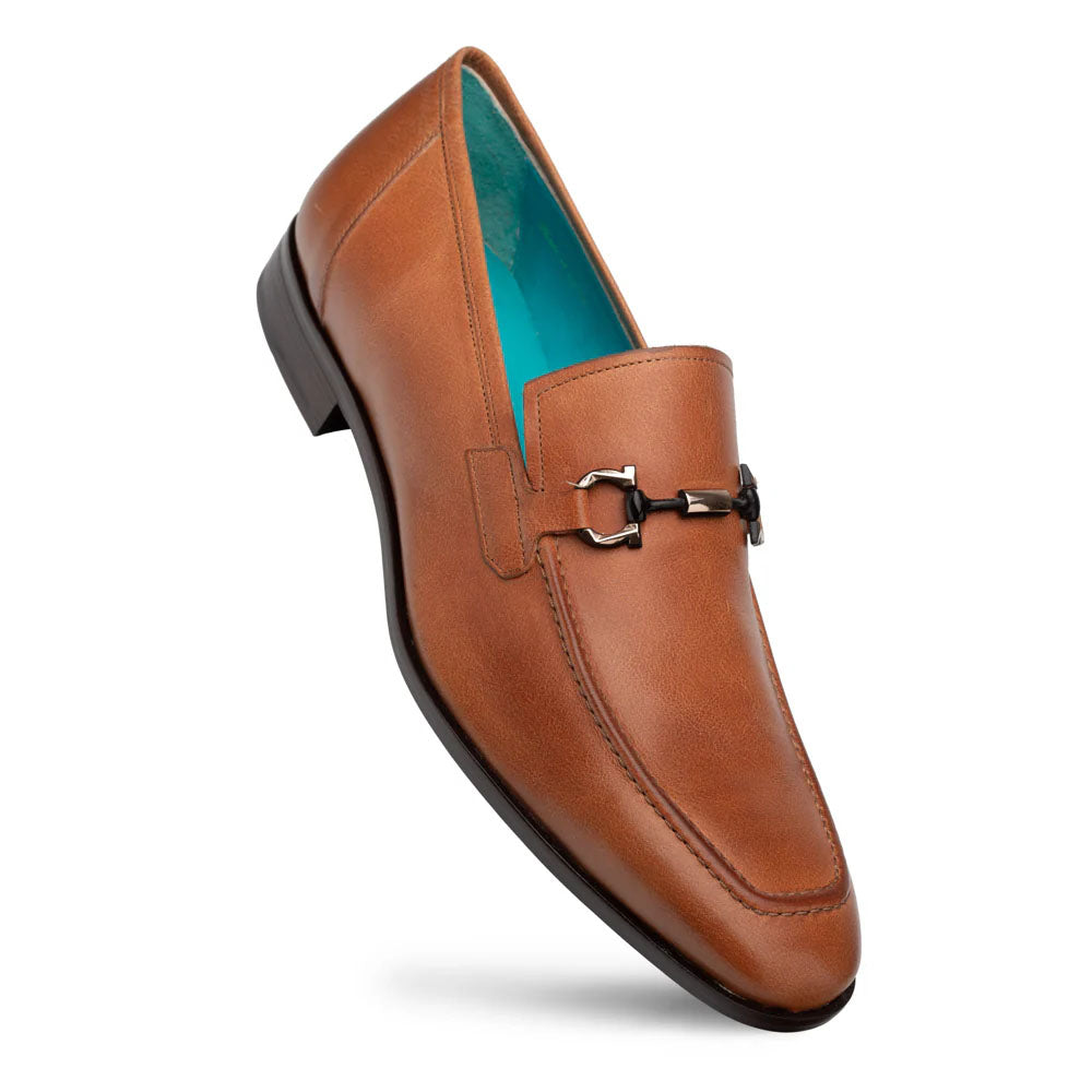 Mezlan Rios Flex Loafer in cognac. Smooth leather upper, tapered shape, and decorative metal ornament. Features contrasting turquoise lining and a stable black rubber sole.

