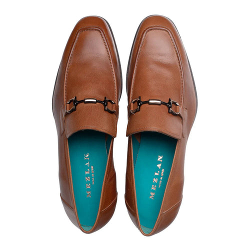 Cognac Mezlan Rios Flex loafer. Smooth leather, pointed toe, low profile. Decorative metal bit. Contrasting blue insole. Sleek, minimal design with clean lines and rounded heel.

