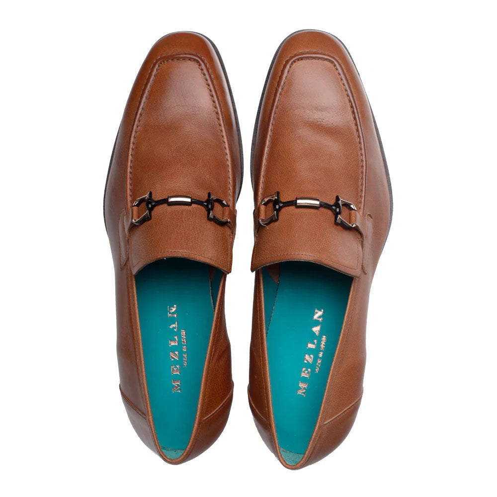 Cognac Mezlan Rios Flex loafer. Smooth leather, pointed toe, low profile. Decorative metal bit. Contrasting blue insole. Sleek, minimal design with clean lines and rounded heel.
