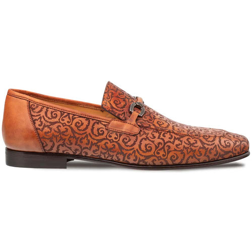 Mezlan Alcaraz slip-on in cognac leather with laser-printed swirling pattern. Low-profile design, pointed toe, decorative strap. Features a stacked black heel and smooth back.
