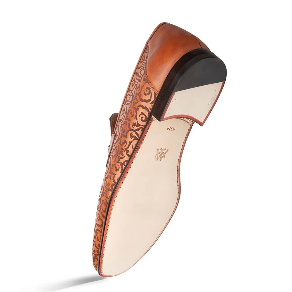 Cognac Mezlan Alcaraz slip-on with laser-printed pattern. Smooth, rounded toe and low heel. Light-colored sole with minimal detailing. Cohesive, slip-on design.
