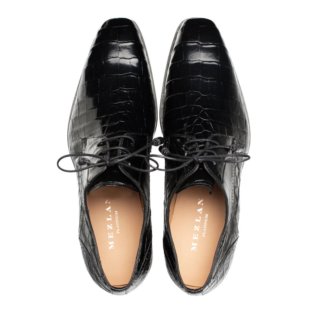 Black Mezlan Dandy lace-up shoe with shiny alligator leather upper and pointed toe. Features textured, scale-like pattern. Streamlined silhouette with smooth interior lining.
