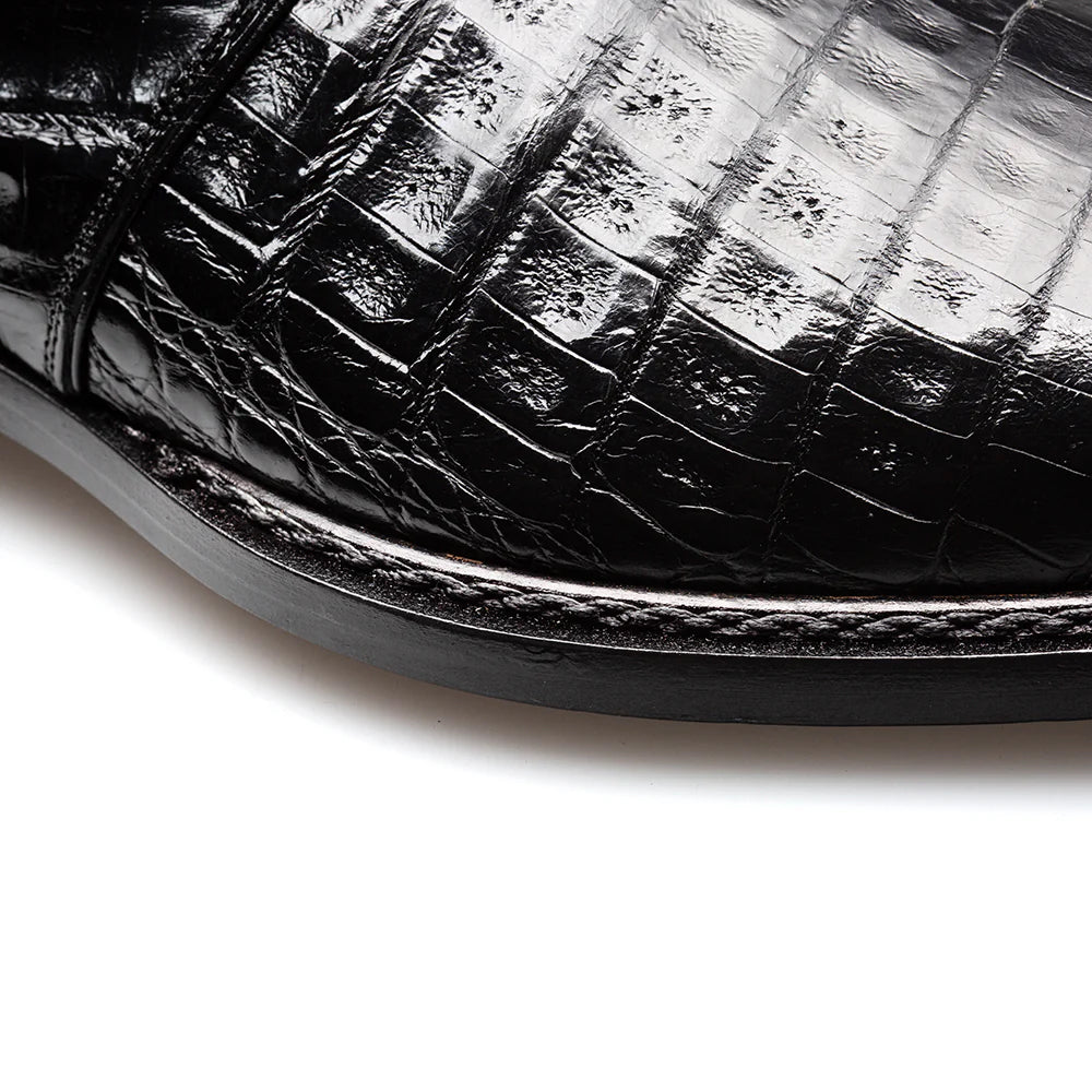 Mezlan Gigolo Monk Strap in black crocodile leather. Squared toe, single strap, and textured upper. Rounded heel with contrasting stitching. Black, flat outsole.
