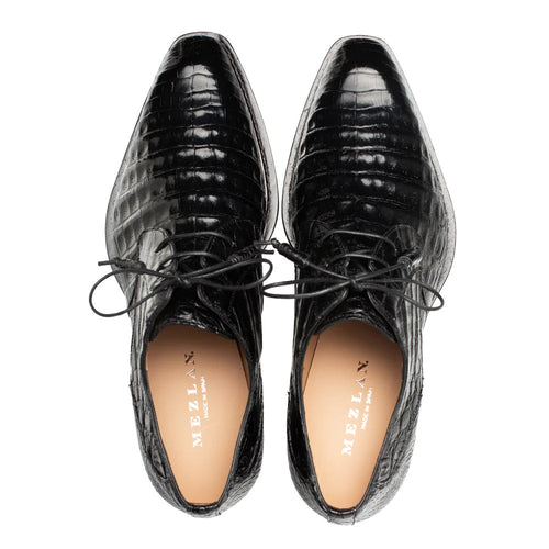 Black Mezlan Cratos Derby, crafted from glossy crocodile leather. Features a pointed toe and scale texture. Lace-up closure with contrasting insoles.
