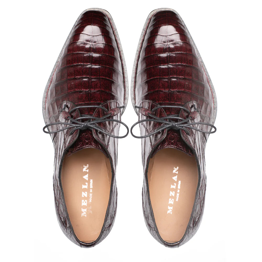 Mezlan Cratos Derby: Burgundy crocodile leather, elongated shape, glossy finish, textured pattern. Black laces, light lining. Pointed design.
