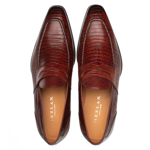 Cognac Mezlan Mayor Lizard Penny Loafer. Smooth, rounded toe with a low profile. Glossy, textured lizard pattern. Stitched vamp detail, classic penny strap. Light leather lining, leather outsole.
