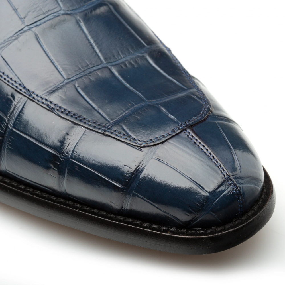 Mezlan Piccolo penny loafer in blue alligator. Pointed toe, polished finish. Textured deep blue alligator upper with contrasting stitching. Black leather sole.
