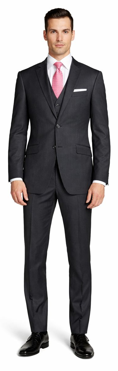 Mantoni charcoal wool suit by Albertonardoni. Fitted, single-breasted, two-button design. Charcoal gray wool. Slim-fit trousers. Two front pockets, breast pocket. Smooth texture. Styled with a light shirt and pink tie.
