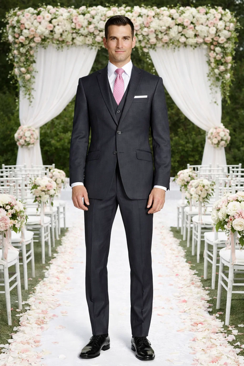 Mantoni charcoal wool suit by Albertonardoni. Tailored two-button jacket, notched lapel. Charcoal wool with a smooth texture. Straight-leg, slim-fit pants. White pocket square, pink tie, and white shirt offer contrast. Sleek and formal.
