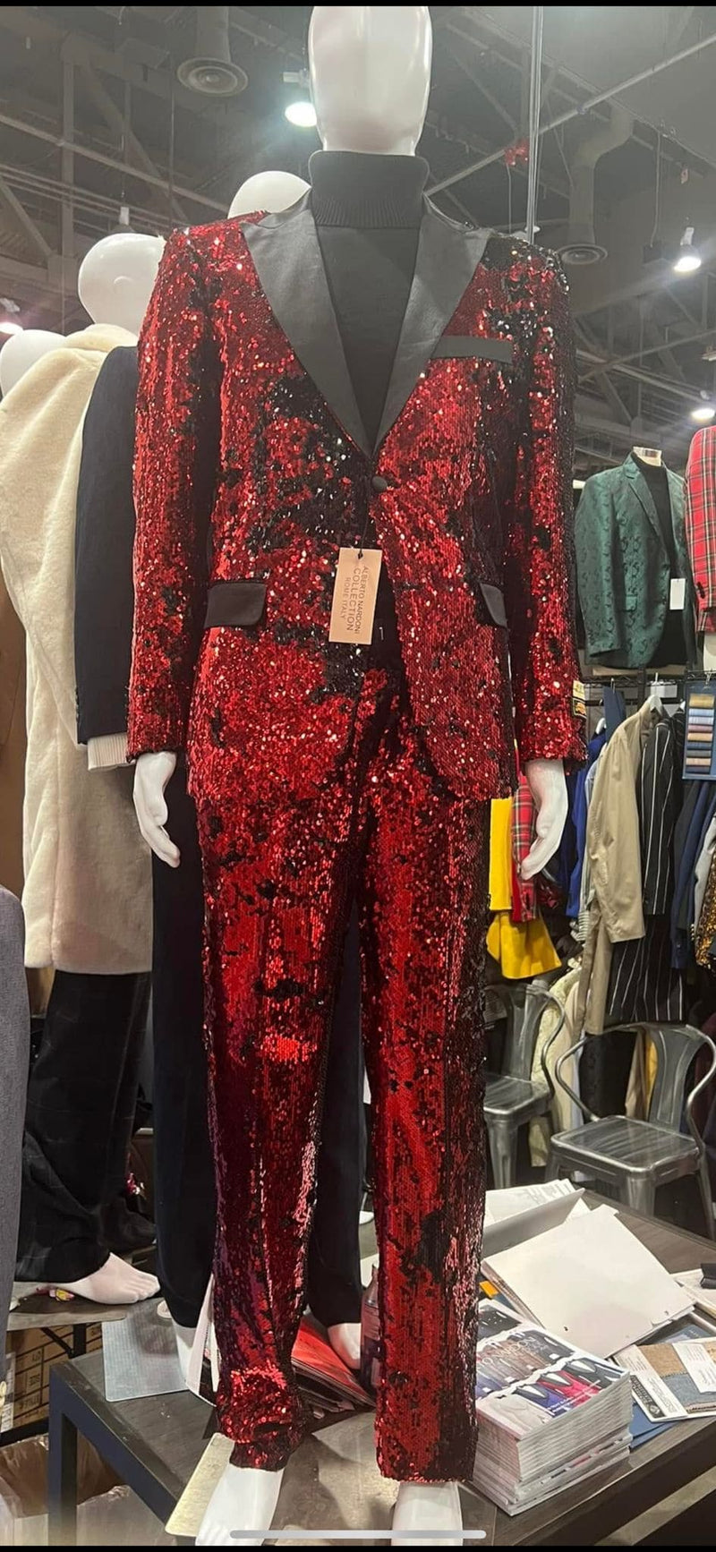 Men's red sequin tuxedo suit. Slim fit blazer with black lapel, single-button closure, and side pockets. Matching pants. Luxury and stylish.
