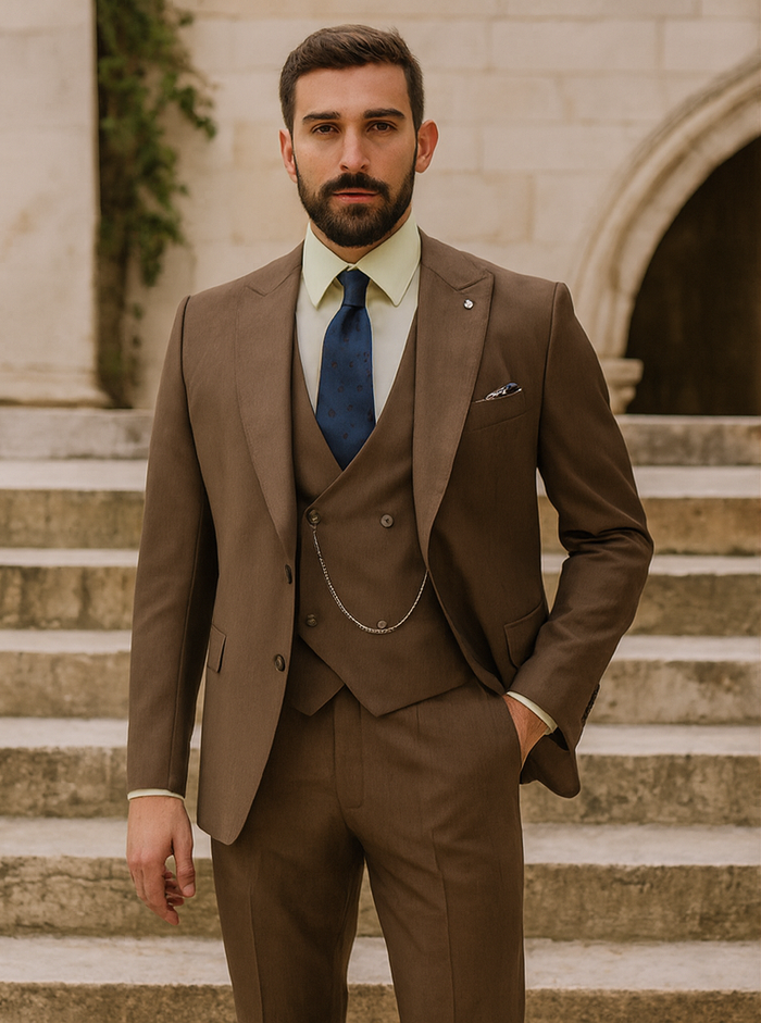 Designer brown suit with fitted jacket & vest. Smooth, solid fabric with sheen. Includes shirt, tie & pocket square. Jacket: 2 buttons, sharp lapels. Pants: straight leg. Chain accessory.