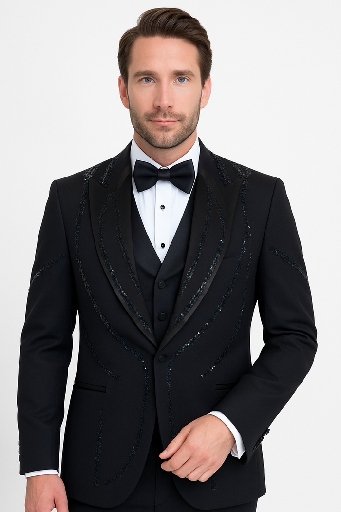 Modern fit black Italian wool tuxedo. Tailored jacket with satin peak lapel and sequin detailing. Matching waistcoat and trousers. Smooth, rich texture.
