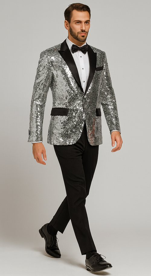 Silver sequin tuxedo for men: shimmering silver sequins jacket with black satin lapel and pocket accents. Paired with black tapered trousers. A formal, eye-catching silver and black ensemble.

