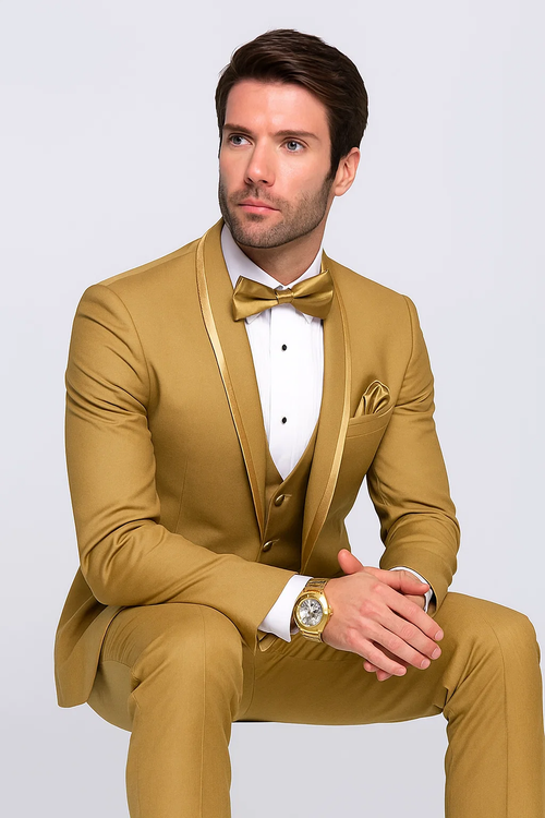 Gold champagne tuxedo with satin finish. Features: shawl collar, 3-piece vest, pocket square. Fitted shape, structured shoulders, tailored sleeves. Includes white dress shirt, black buttons, gold bow tie.