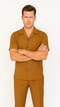 Caramel-colored men's leisure suit: short-sleeve button-up shirt with chest pocket & matching pants. Smooth, solid color finish for a relaxed, stylish look.
