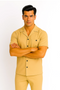Men's sand-colored walking suit: short-sleeved shirt with spread collar, two black buttons, chest pocket, and matching straight-cut pants. Lightweight fabric, ideal for casual wear.
