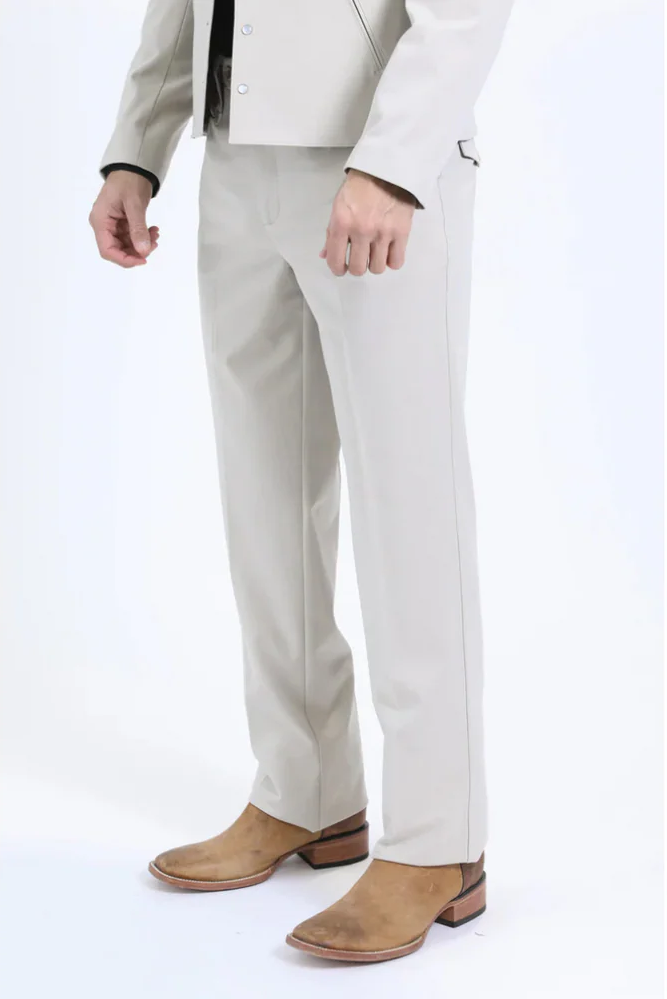 White Western sport suit. Lightweight fabric, fitted jacket with structured collar. Straight-cut pants with subtle seam detailing, streamlined silhouette. Light brown footwear.
