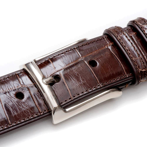 Dark brown Mezlan AO7907 alligator belt with a textured surface & silver rectangular buckle. Features include distinct skin patterns, adjustable holes, & neatly stitched edges.