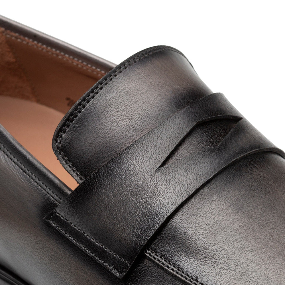 Dark grey Mezlan Avenue penny loafers. Smooth leather upper with classic penny slot design. Durable rubber sole. Visible stitching for structure and refined finish.
