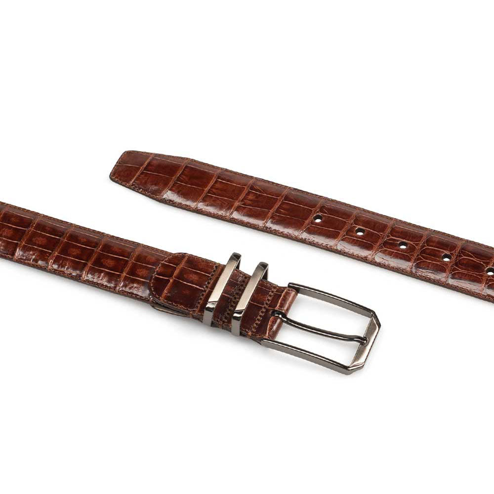 Mezlan crocodile belt: narrow, elongated shape with textured surface and crocodile pattern. Rich brown color, featuring a metal buckle.
