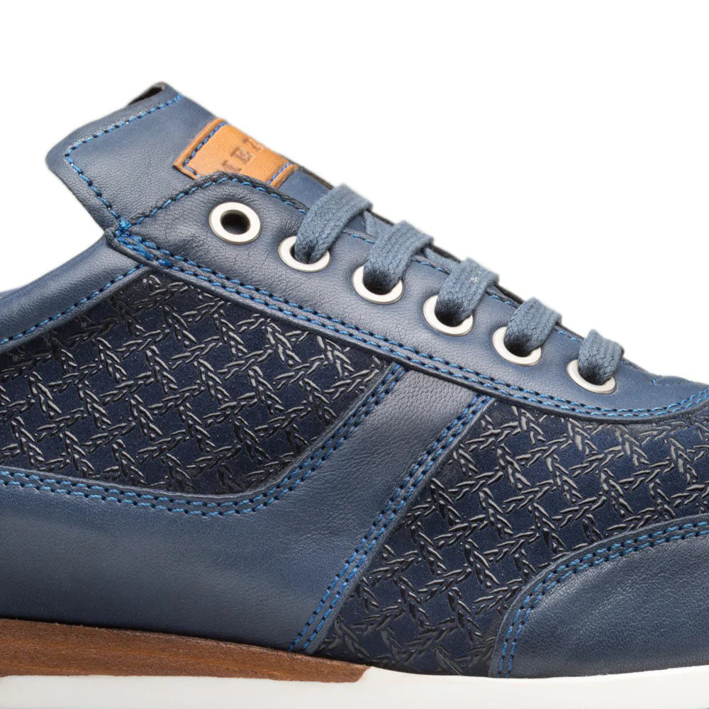 Mezlan Maxim blue calfskin sneakers. Structured design with smooth leather upper and textured detailing. Matte blue leather body with patterned side. Round toe, flat white sole, gray-blue laces. Tan leather collar label.
