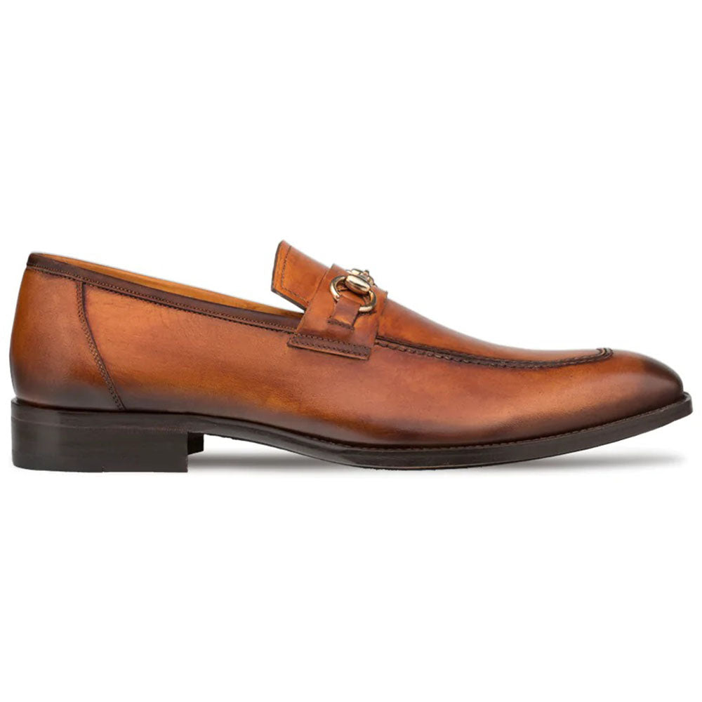 Mezlan cognac loafers: smooth leather, rounded toe, metal ornament. Minimal seams, dark sole for stability. Cushioned insole, flat, slightly raised heel. Stylish and comfortable.
