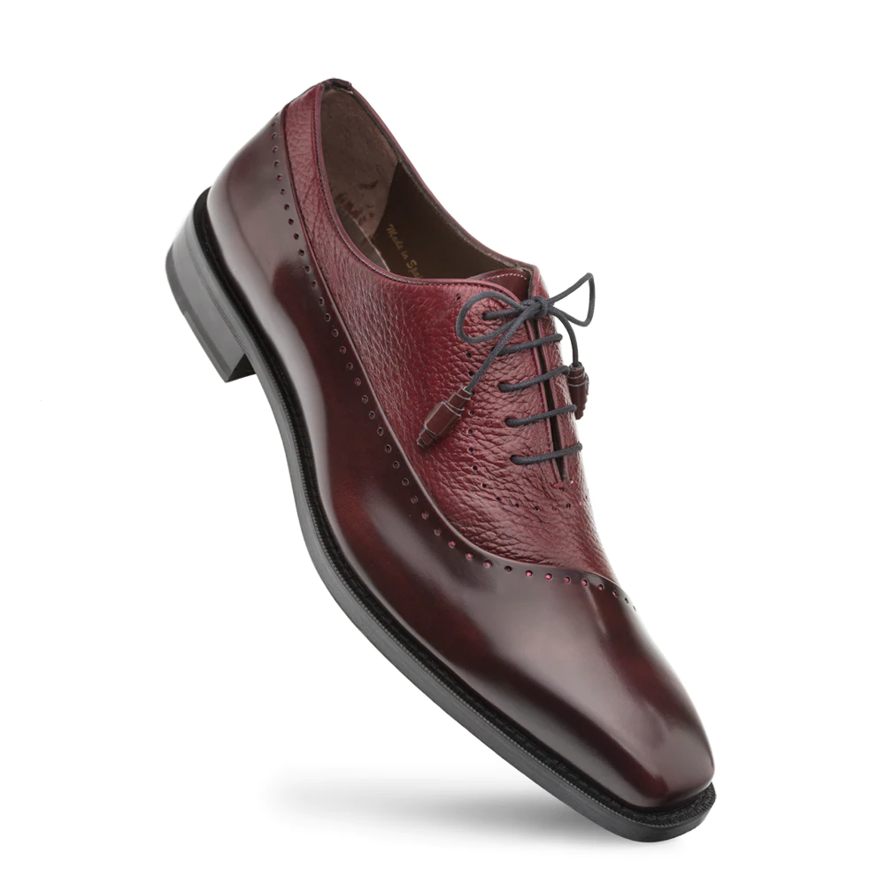 Burgundy Mezlan Postdam shoes. Deerskin/calfskin blend. Rounded toe, smooth finish with textured and glossy sections. Decorative perforations. Lace-up with gray laces. Black rubber sole.
