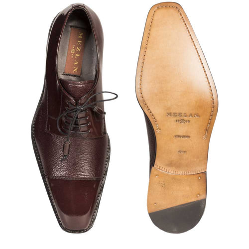 Burgundy deerskin Mezlan Soka oxford. Smooth upper with textured vamp panel. Pointed cap toe, lace-up closure, and contrasting stitched leather sole with rubber heel cap for durability.
