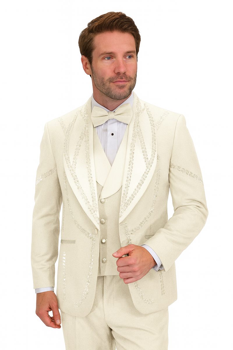 Off-white Italian wool tuxedo. Modern fit, three-piece. Single-breasted jacket with shawl collar and ornate stitching. Includes waistcoat and matching trousers. Light cream color.
