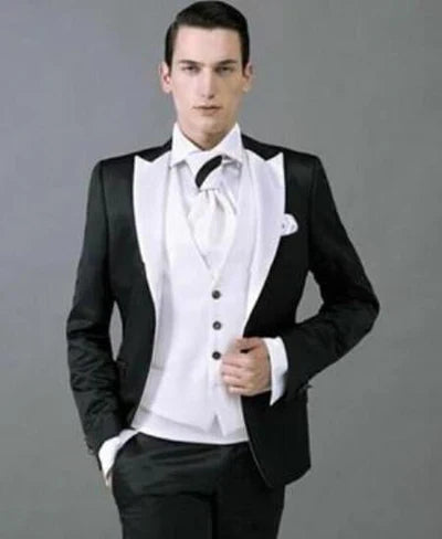 Men's black & white prom tuxedo suit: Black jacket with white satin peaked lapel, black vest, white dress shirt. Single-button closure, tailored fit.
