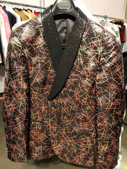 Men's black designer blazer with red & gold abstract pattern. Features a black textured shawl collar and two front pockets. Shiny fabric.
