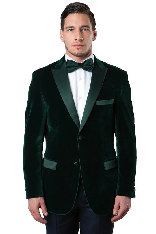 Dark green velvet tuxedo jacket. Single-breasted, fitted silhouette. Notched lapels, minimalist pockets, and buttoned cuffs. Plush velvet fabric enhances the rich color and smooth texture.
