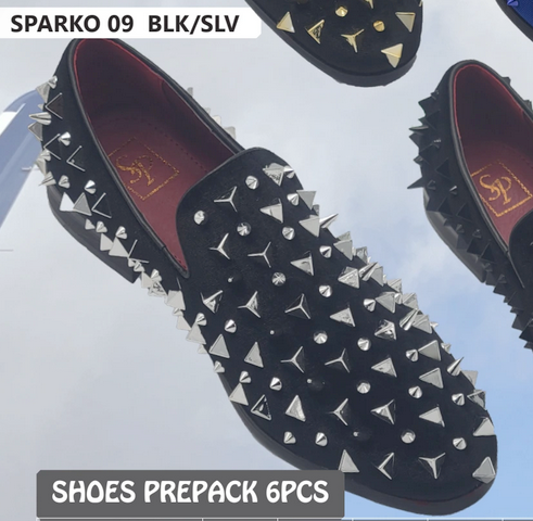 Men's black slip-on loafers with flat design. Silver spikes and studs detail the soft, black fabric upper. 
