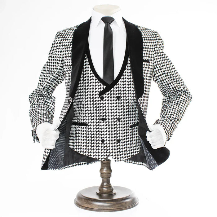 Men's houndstooth tuxedo set: black & white. Structured blazer with velvet lapel, double-breasted vest, and black trousers. Classic pattern.

