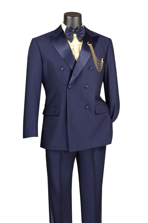 Navy double-breasted tuxedo with satin peak lapel. Subtle textured fabric. Matching trousers. Gold chain detail on the left pocket. Classic and elegant.
