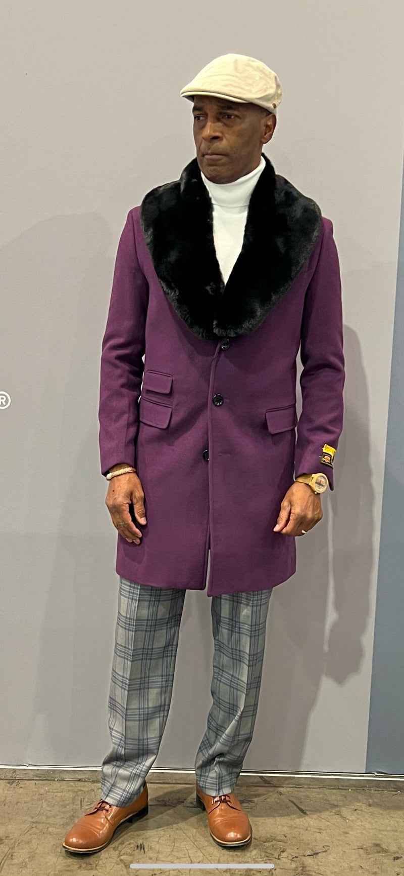 Men's purple wool overcoat with black faux fur collar. Tailored silhouette, three-button front, and two pockets. Stylish and warm.
