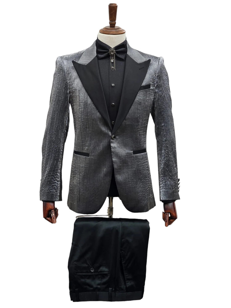 Silver metallic tuxedo suit with textured finish, black satin peak lapel. Paired with matching black trousers, no patterns.
