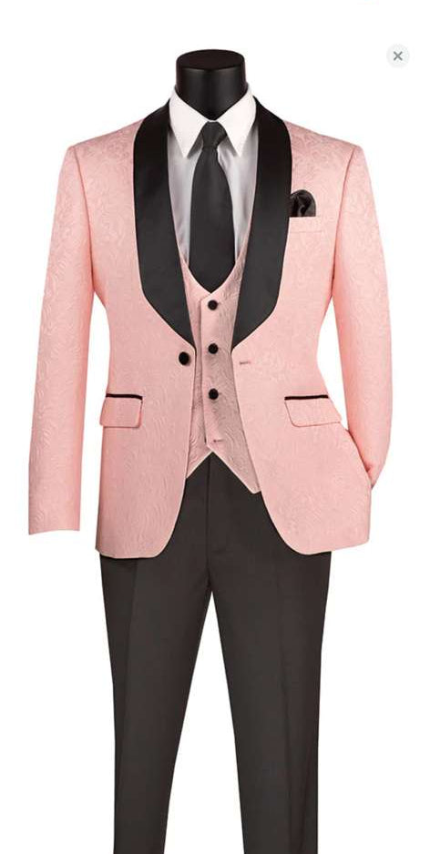 Men's blush pink tuxedo suit: single-breasted jacket with black shawl lapel, textured finish. Matching 3-button vest & classic black tie. Black trousers provide contrast.