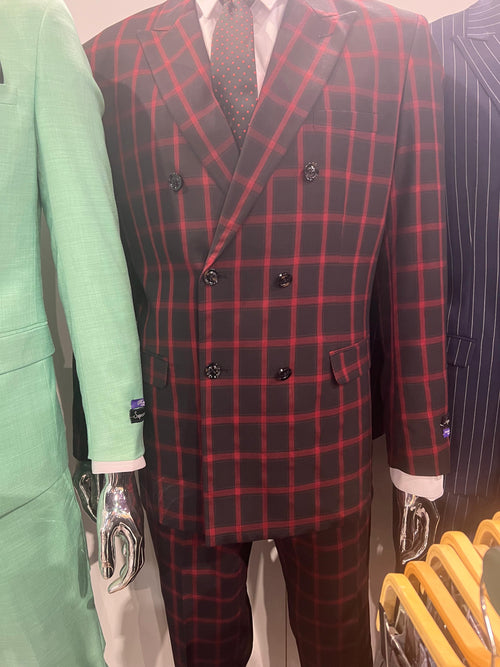 Men’s black and red check double-breasted blazer features a structured form with a notched lapel, front flap pockets, and six buttons. The fabric displays a grid pattern with alternating black and red squares.